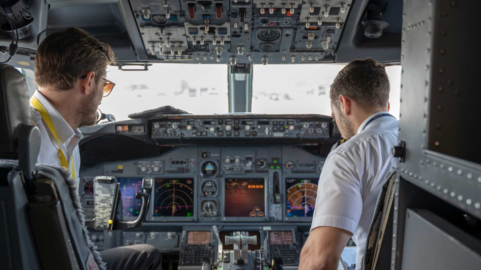 Two pilots in a commercial jet cockpit preparing for flight, illustrating La Casa Jet’s crew training and scheduling services.