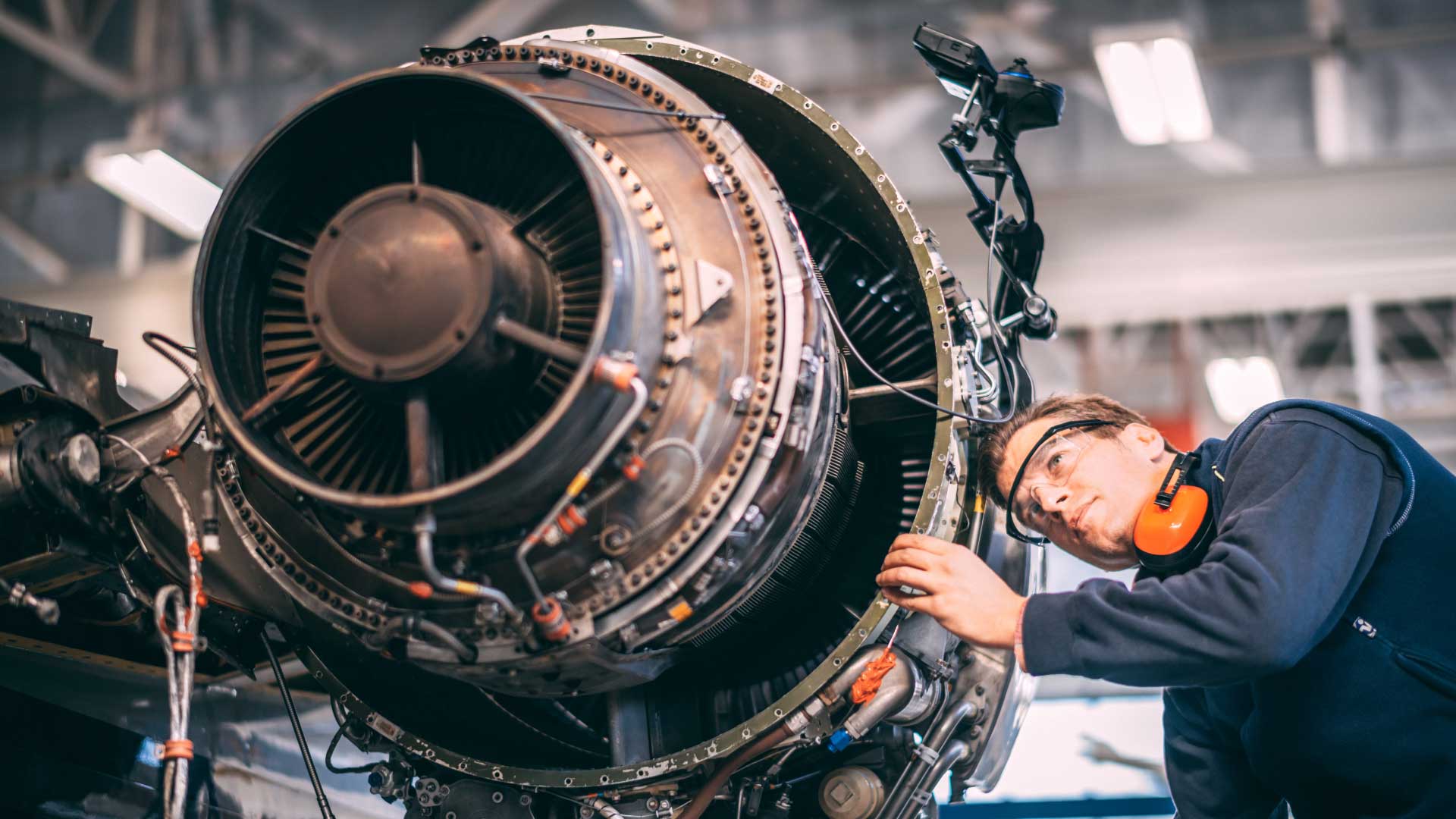Aircraft technician inspecting a jet engine for scheduled maintenance under La Casa Jet’s tracking and oversight program.